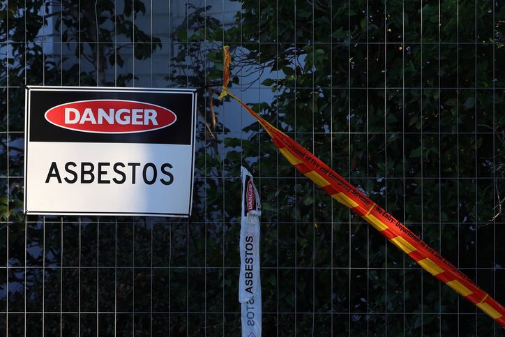 Affiche « Danger amiante » sur une clôture de chantier